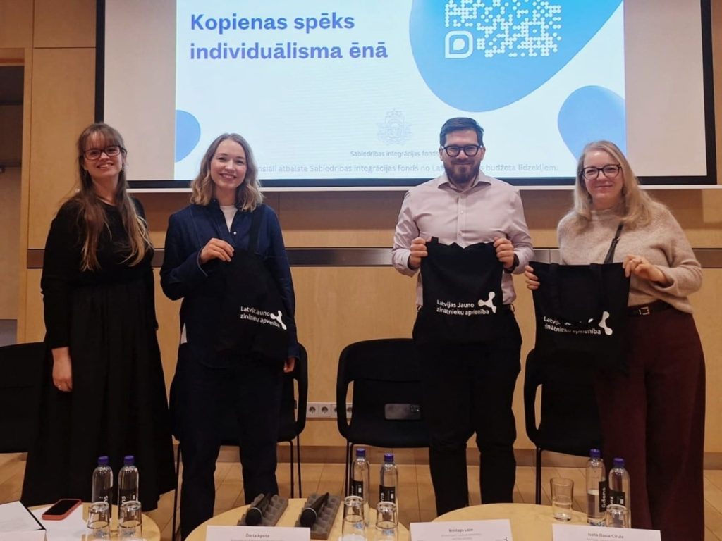 Diskusijas "Kopienas spēks individuālisma ēnā" dalībniekiu kopbilde, turot rokās LJZA maisiņus.